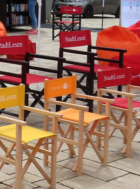 Kinderstühle Nanni in Holzgestell natur beim Stadtlesen Event in verschiedenen Farbkombinationen und mit Logo-Druck.