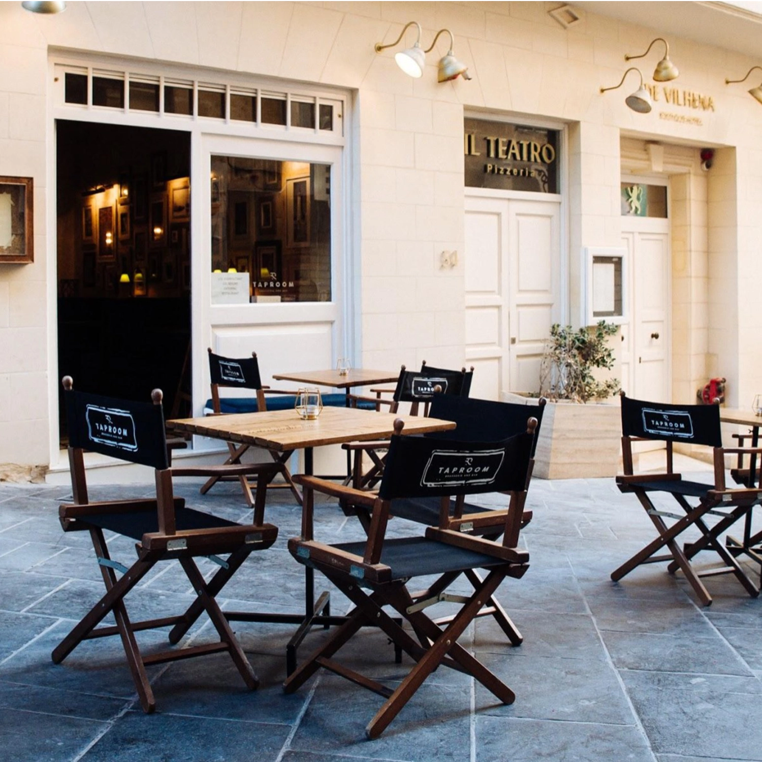 Regiestühle Alfred in braun mit schwarzer Bespannung auf der Außenterrasse eines Restaurants als Sitzlösung für die Gastronomie.