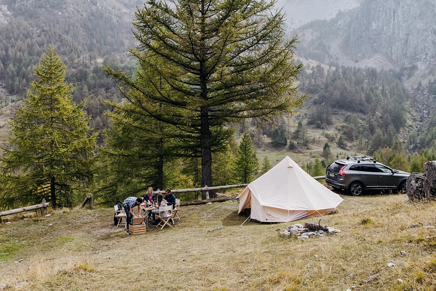 Regiestühle Alfred im Einsatz beim Zelten – mitten in der Berglandschaft, mit Feuerstelle, Freunden und ganz viel Naturgefühl.