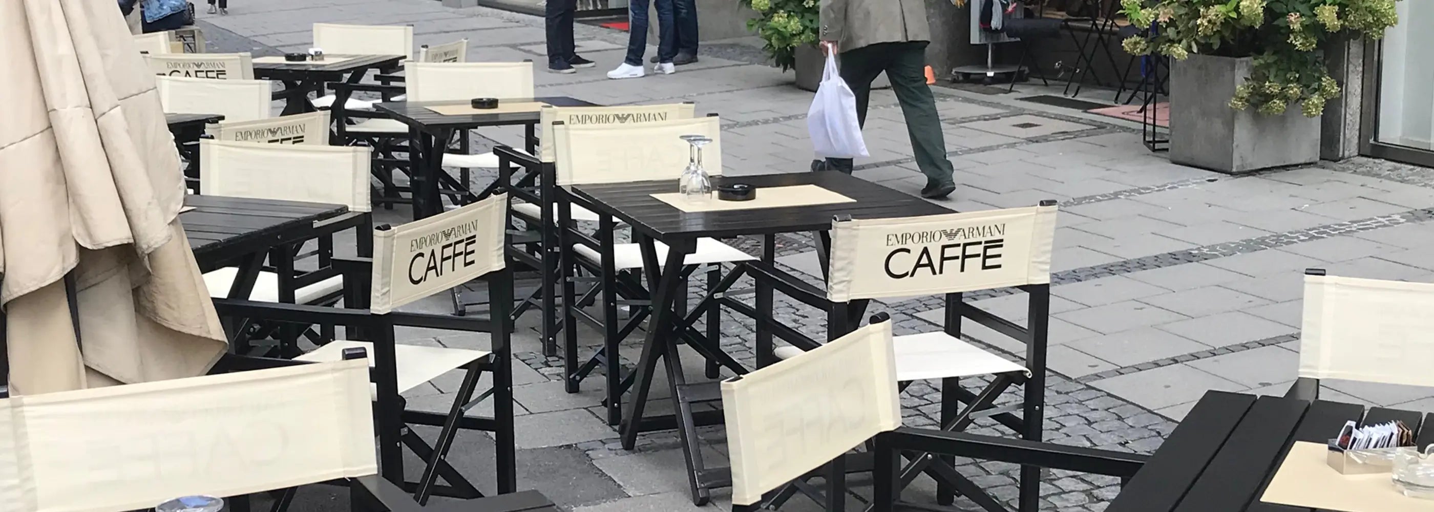 Regiestühle Oscar in schwarz mit Branding für ein Café – eleganter Einsatz in der Außengastronomie.