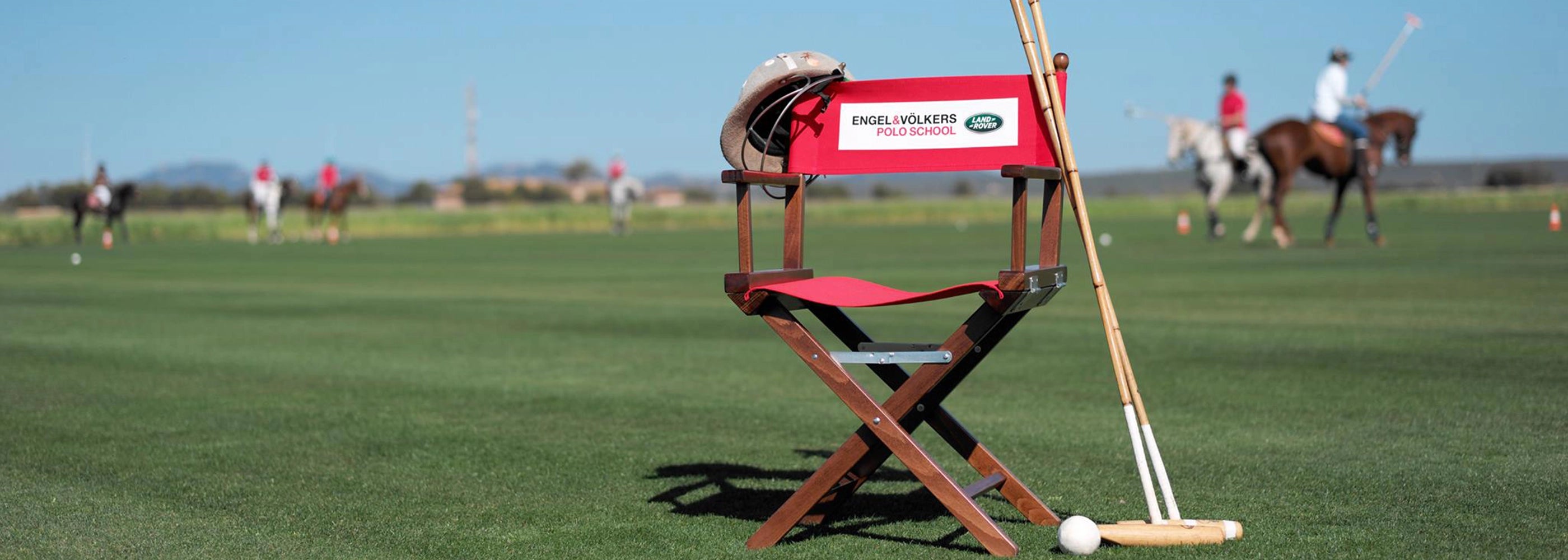 Regiestuhl Alfred mit Poloschlägern und Reithelm auf einem Polofeld – perfekt für Sportveranstaltungen, Vereine oder Outdoor-Events