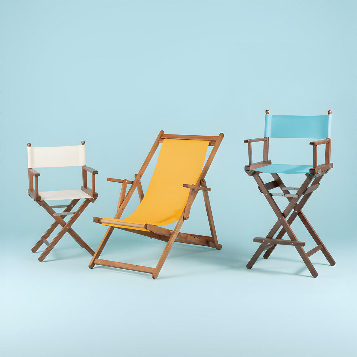 Regiestuhl, Liegestuhl und hoher Regiestuhl im Set – farbenfroh vor hellblauem Hintergrund (Quadrat).