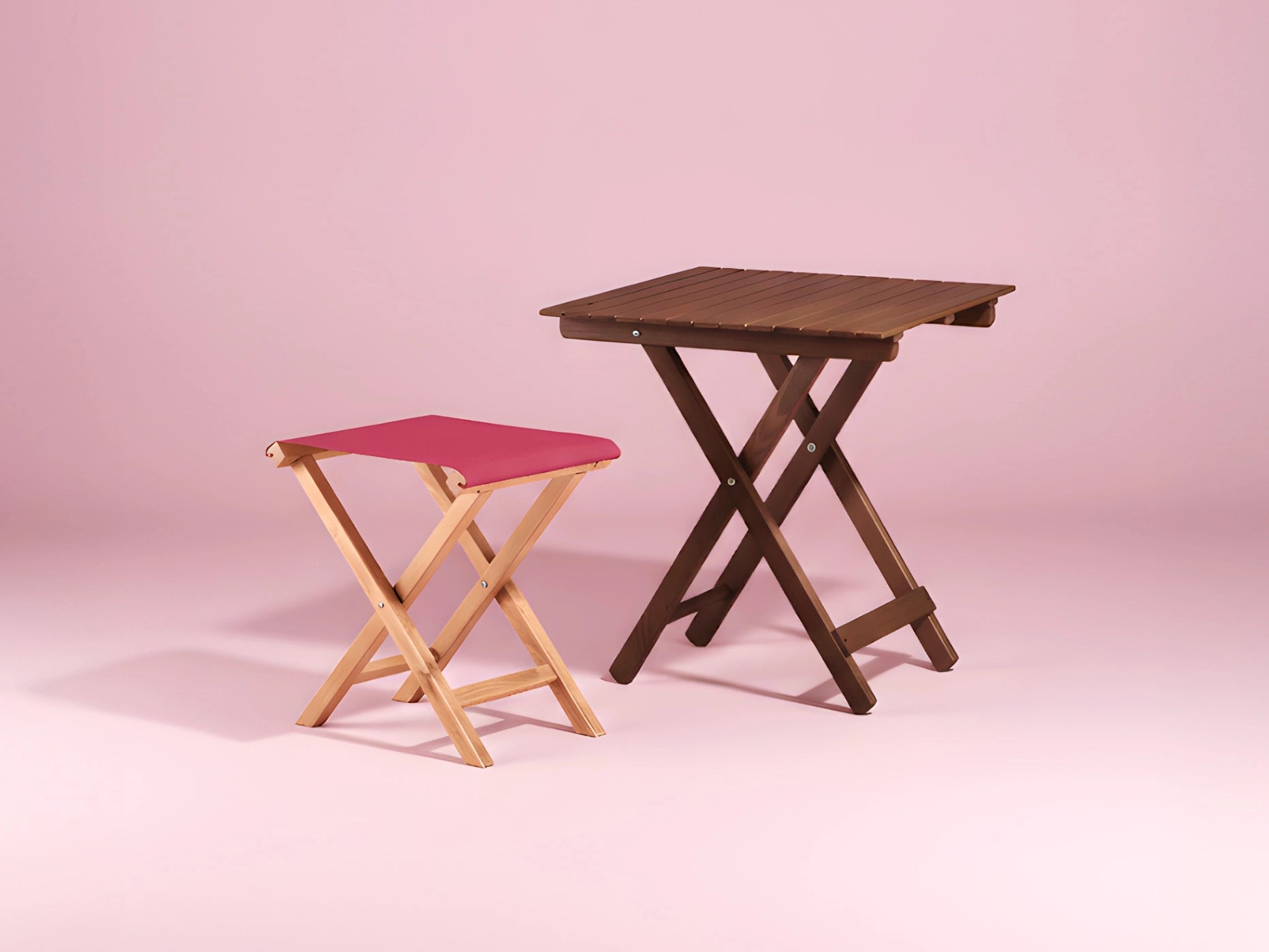 Beistelltisch und Hocker aus Holz mit pinkem Stoff vor pastellrosa Hintergrund
