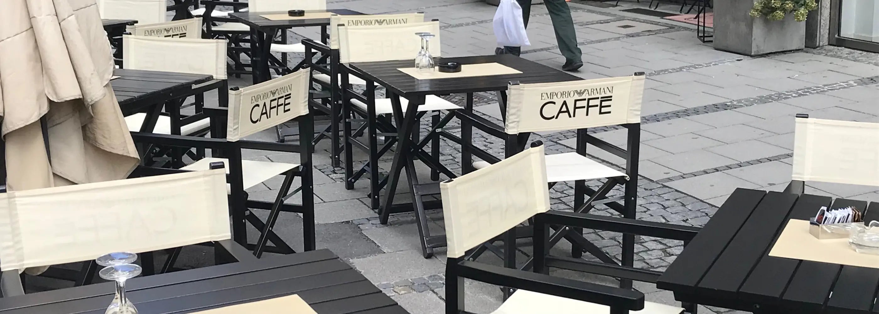 Regiestühle Oscar mit Logo auf einer belebten Café-Terrasse in der Innenstadt