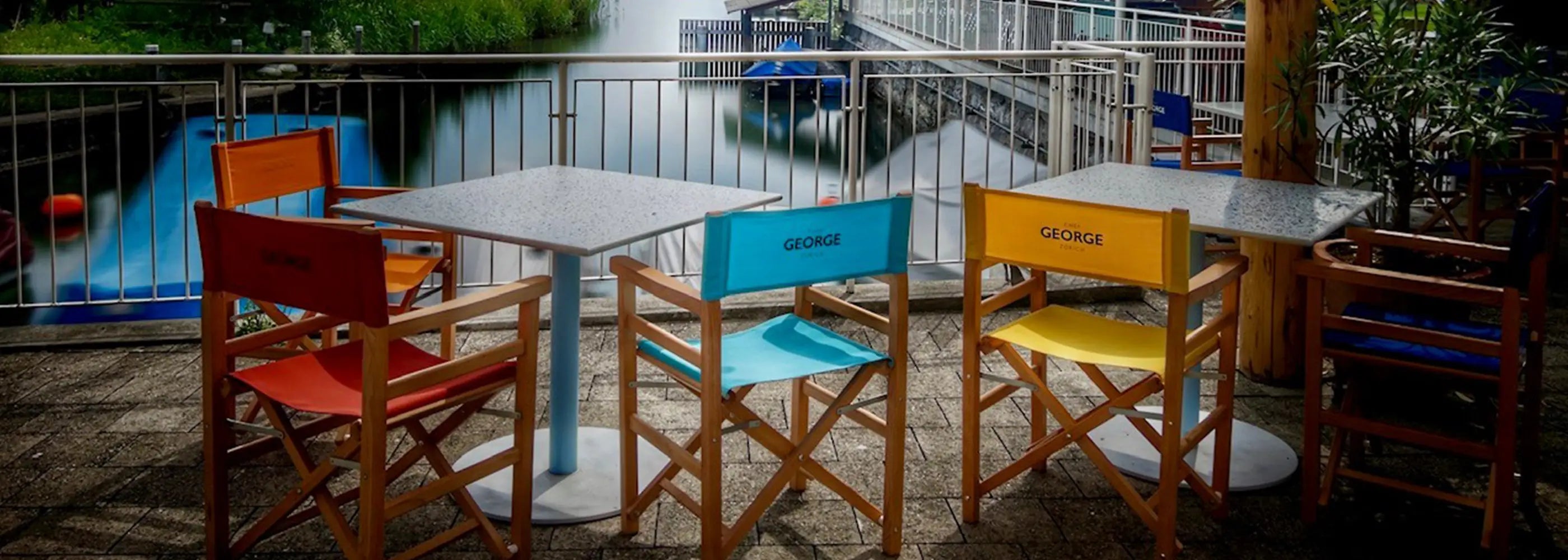 Regiestühle Oscar mit verschiedenen Stoffarben und mit Logodruck auf einer Restaurant-Terrasse direkt am Wasser