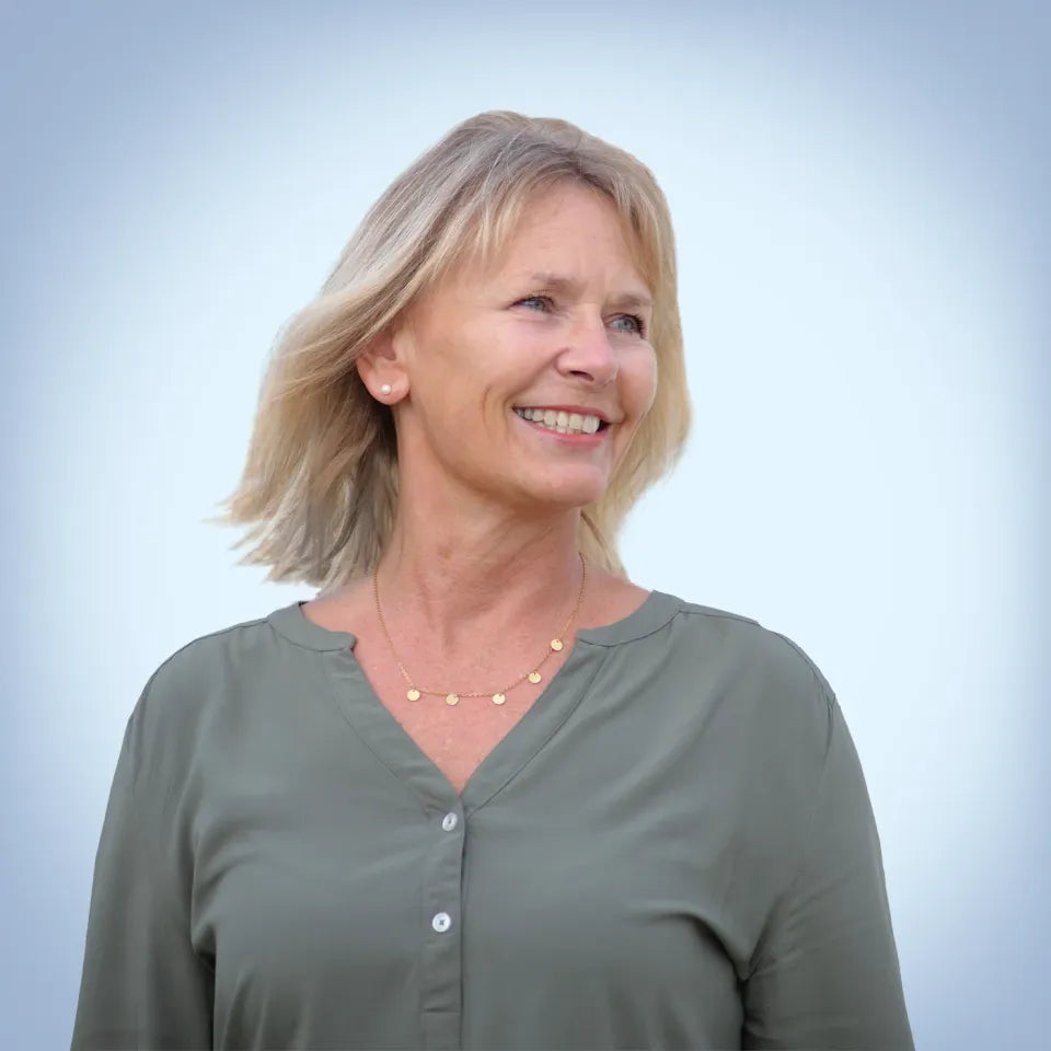 Inka vom Regiestuhl-Team lächelt entspannt vor hellblauen Hintergrund