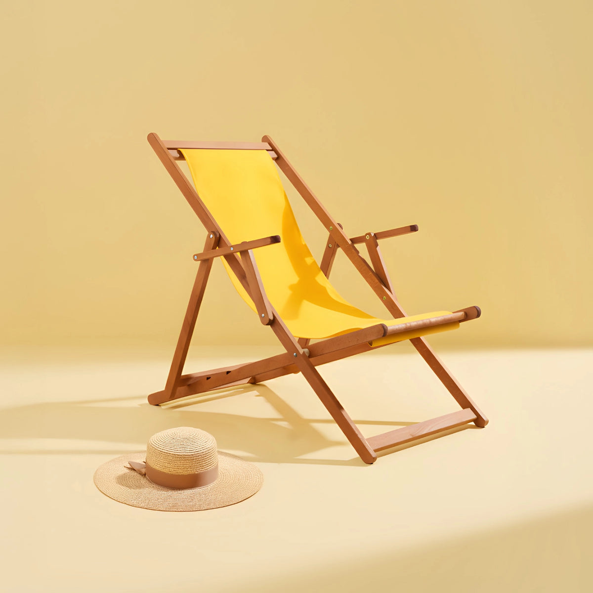 Gelber Liegestuhl aus Holz mit Sonnenhut daneben vor monochrom gelbem Hintergrund (quadratisch)